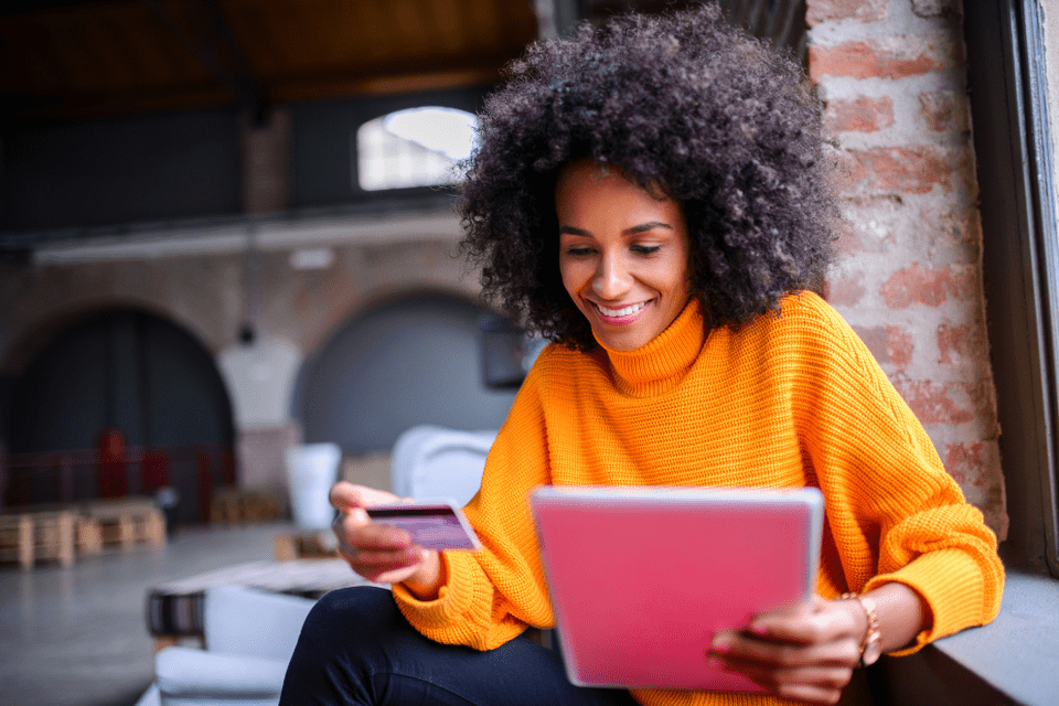 a woman holding both her card and a tablet